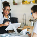 Engaging Experiences: 3 Ways Interactive POS Systems Will Transform Entertainment Venues Waitress swiping customers bank card on pos terminal at restaurant