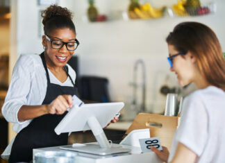 Waitress swiping customers bank card on pos terminal at restaurant