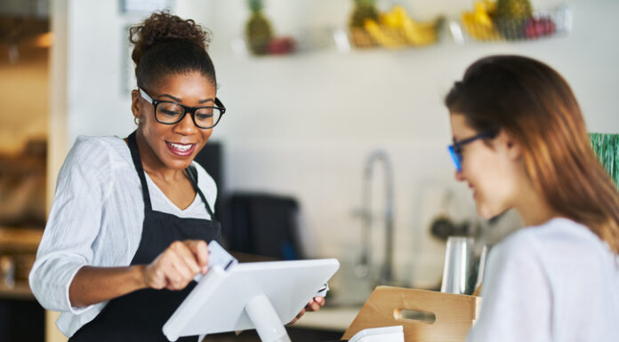 Waitress swiping customers bank card on pos terminal at restaurant