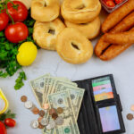 Produce with wallet and money on white table.