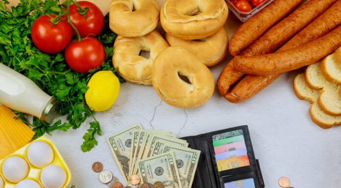 Produce with wallet and money on white table.