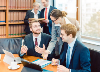 How Law Firms Can Leverage Technology to Streamline Learning and Development Lawyers in their law firm working on computer with books