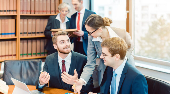 How Law Firms Can Leverage Technology to Streamline Learning and Development Lawyers in their law firm working on computer with books