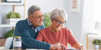 Retirement Decisions: Navigating Your Financial Landscape with Confidence Elderly married couple sitting at the desk with a paper receipt in hands are calculating expenses, managing the budget.