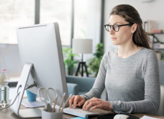 Professional woman sitting at desk and connecting with her computer