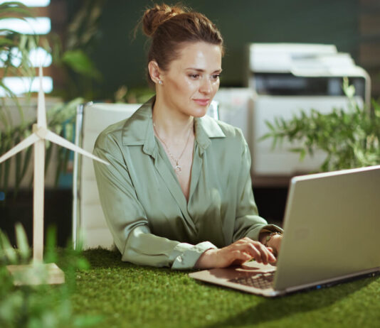 Pensive elegant business woman in green office working