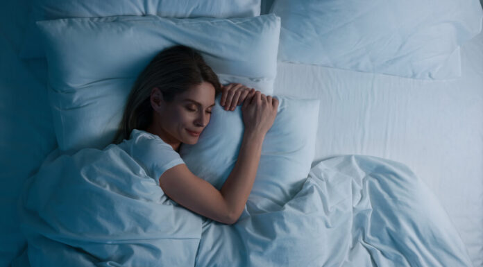 Woman sleeping in bed at night, above view.