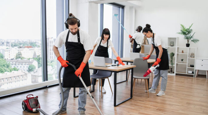 How to Choose the Right Cleaning Service for Your Needs Team of young multicultural cleaners vacuums floor, wipes tables with gadgets, shelves, washes windows in spacious, bright, modern office. Professional cleaning company.