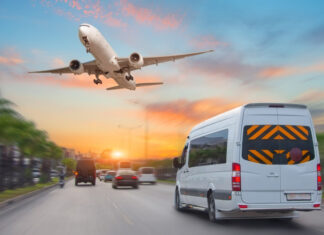 Mini bus drives along the highway among other cars in the evening in the sunset sky