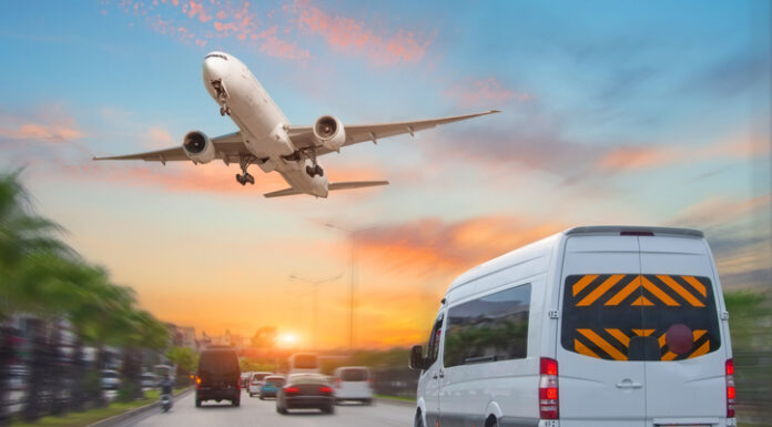 Mini bus drives along the highway among other cars in the evening in the sunset sky