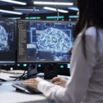 Programmer using AI tech on computer to do maintenance in server room providing storage.