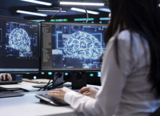 Programmer using AI tech on computer to do maintenance in server room providing storage.