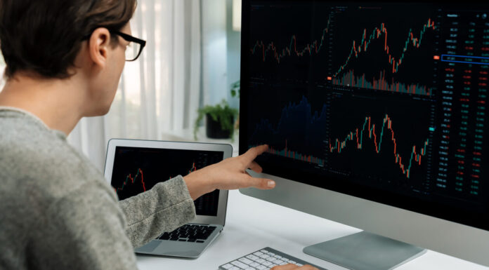 Crypto for Beginners: The Global Debt Crisis: Understanding the Risks and Challenges Investors pointing interesting stock exchange on pc with laptop