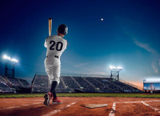 Baseball player at professional baseball stadium in evening during a game.