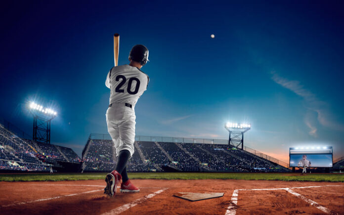 Baseball player at professional baseball stadium in evening during a game.