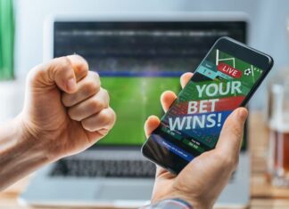 Lucky man celebrating victory after making bets using gambling mobile application on his phone.