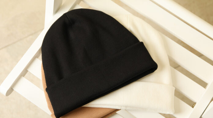 Network and Spread Joy with Personalized Beanies as Business Gifts Three stylish beanies on wooden chair, top view