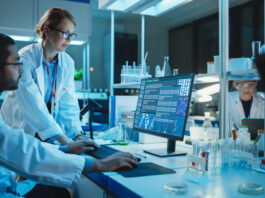 Female Research Scientist with Bioengineer Working on a Personal Computer with Screen Showing Gene Analysis Software User Interface.