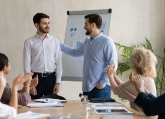 Recruiting the Best Sales and Marketing Personnel: Effective Strategies and Insights Young Caucasian businessman introduce new male employee or worker at group meeting in office.