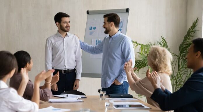 Recruiting the Best Sales and Marketing Personnel: Effective Strategies and Insights Young Caucasian businessman introduce new male employee or worker at group meeting in office.