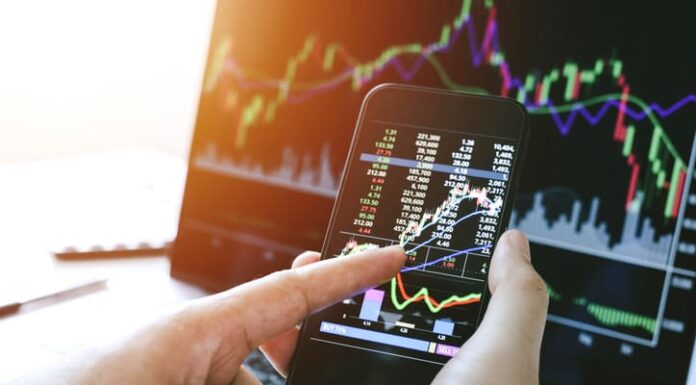 EnviFX.com Unveils New Account Options to Optimize Trader Experience Businessman hand holding phone and analysis finance market graph stock market trading
