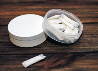 Snus box with nicotine pouches on wooden background