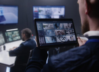 Close up shot of security officer zooming CCTV cameras with AI facial scanning