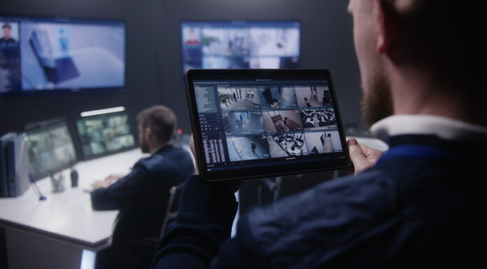 Close up shot of security officer zooming CCTV cameras with AI facial scanning