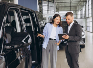 Lady Buyer Standing In Luxury Automobile Dealership Store.