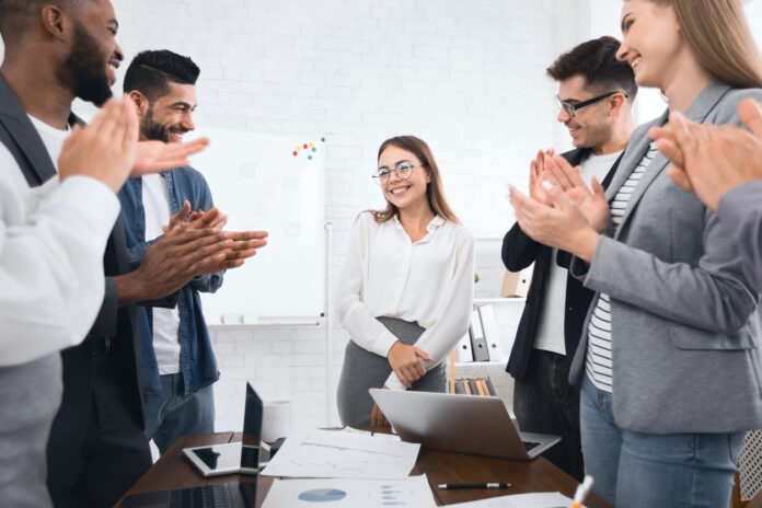 Business team congratulating successful female manager with applause leader introvert