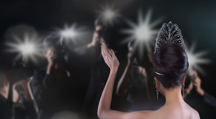 Back side view of Miss Pageant beauty contest with Silver Diamond Crown wave hand to many Photographers