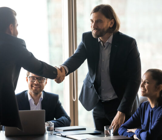 The Truth About Interim Consultants: High-Impact, Cost-Efficient, and Ready to Enrich Your Business Smiling businessmen handshake closing successful deal at meeting