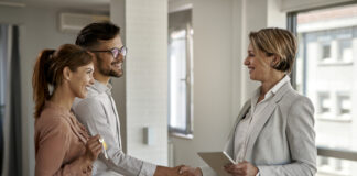 Legal Pitfalls for First-Time Homebuyers and How to Avoid Them Happy couple greeting a real estate agent while buying a new home