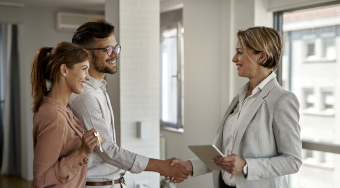 Legal Pitfalls for First-Time Homebuyers and How to Avoid Them Happy couple greeting a real estate agent while buying a new home