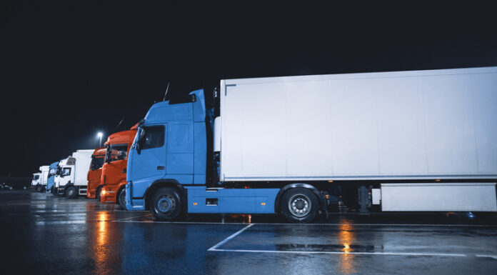 Benefits of Hiring a Semi Trailer Line of Semi-Trucks with Cargo Trailer Drives Standing on the Overnight Parking Place