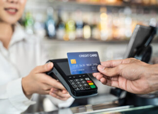 Close up shot of customer hand using dummy credit card for payment to waitress at cashier in cafe restauran