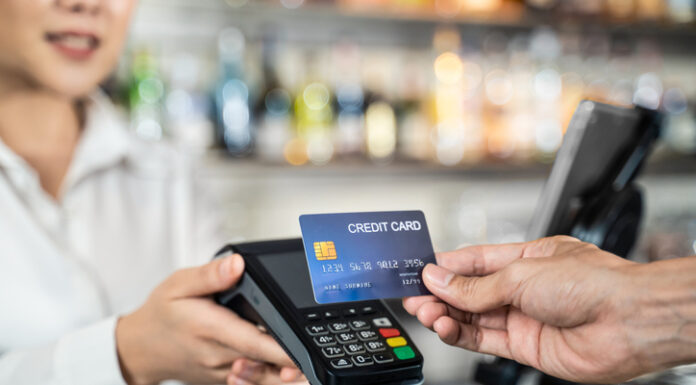 Close up shot of customer hand using dummy credit card for payment to waitress at cashier in cafe restauran