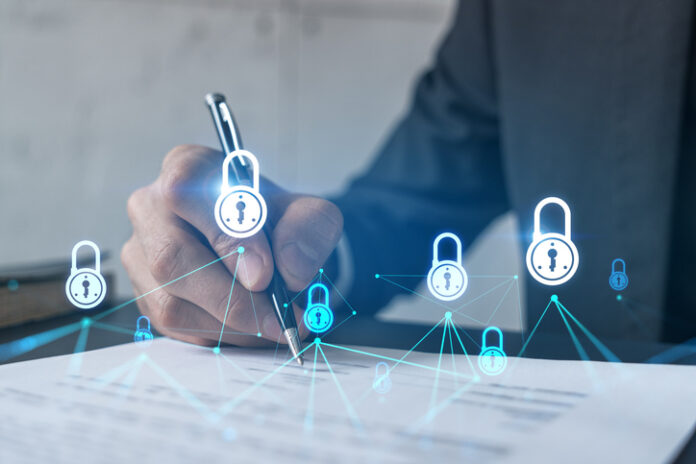 Businessman in suit signs contract. Double exposure with lock icon hologram.