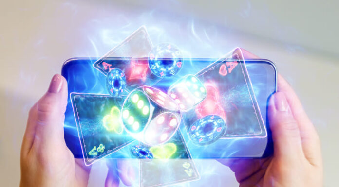 in a man's hand a smartphone with playing cards neon, roulette and chips, neon background