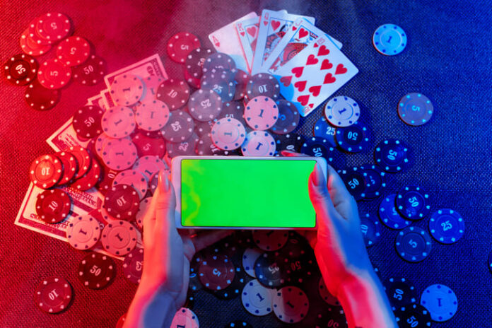 Playing cards, betting Chips and a smartphone with a copy space in women's hands