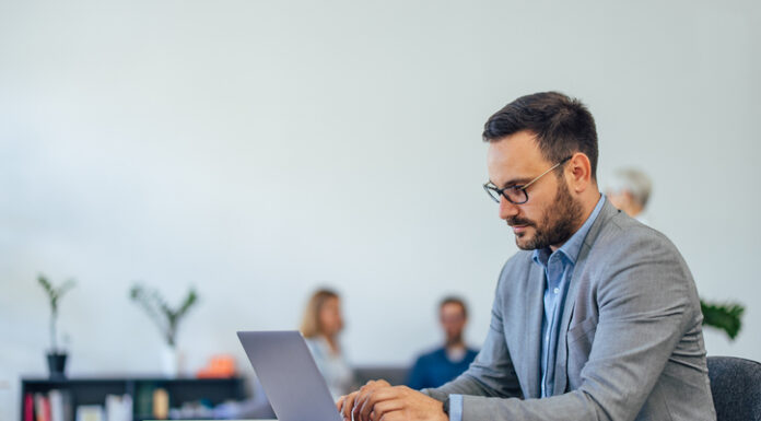 10 Benefits of Microlearning in the Workplace Serious-looking businessman using a modern technology, a laptop.