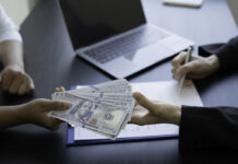 From Clicks to Conversions: Mastering Loan Affiliates Person handing dollars to someone