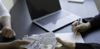 From Clicks to Conversions: Mastering Loan Affiliates Person handing dollars to someone