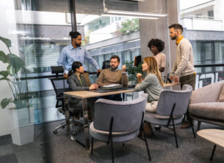 The Role of a Leader’s Habits in Shaping Organisational Culture International workers group and team leader having teamwork discussion managing project at work in meeting room.