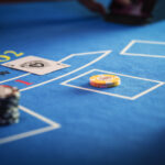 Anonymous Croupier Dealing Playing Cards on a Blackjack Table with Bet Chips in Place.