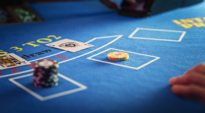Anonymous Croupier Dealing Playing Cards on a Blackjack Table with Bet Chips in Place.