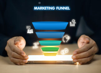 Content Marketing Funnel: Strategies for Every Stage of Your Customer’s Journey A person is holding a tablet with a marketing funnel on it