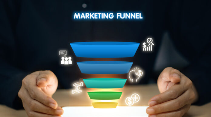 Content Marketing Funnel: Strategies for Every Stage of Your Customer’s Journey A person is holding a tablet with a marketing funnel on it