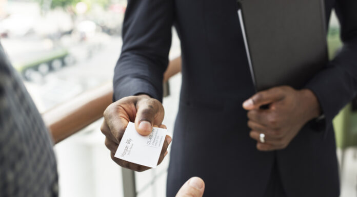 Trendy Business Card Ideas to Stand Out in 2024 Businessman holding business card giving to another