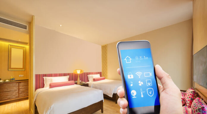 5 Smart Automation Solutions for Happier Guests and Improved Hotel Operations Smart phone with modern bedroom